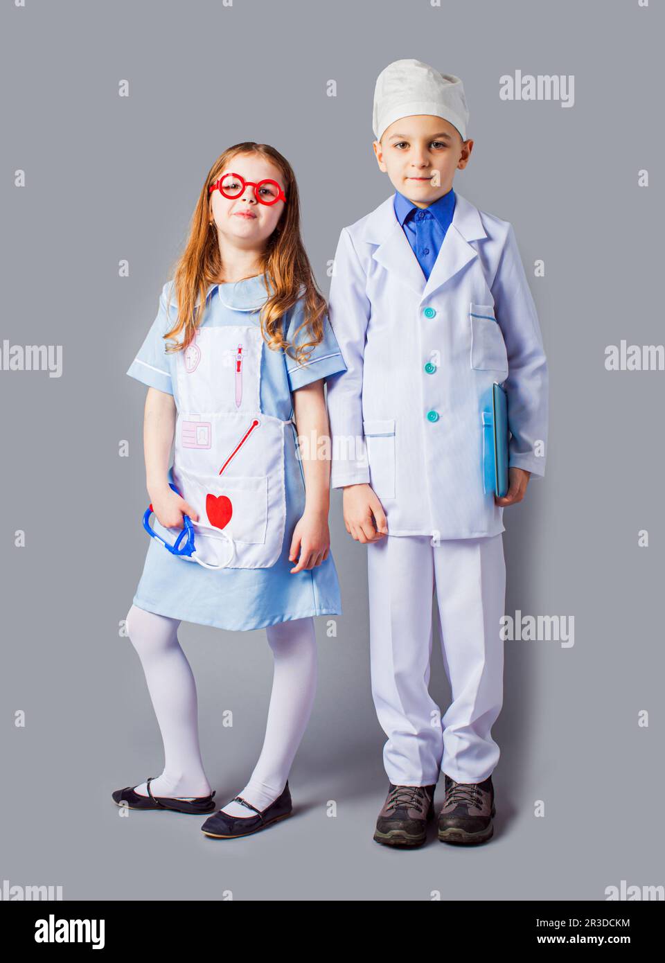 Cute boy and girl in medical uniform playing like doctors Stock Photo
