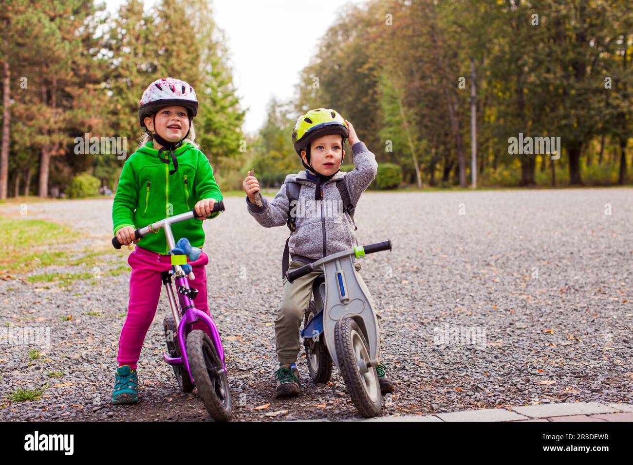 Sweet kids on balance bikes outdoors at the park Stock Photo
