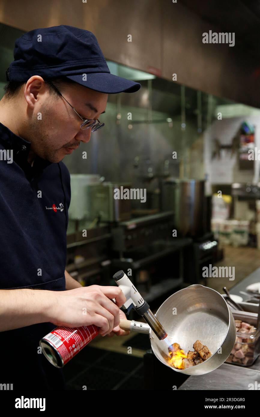 Bobby Siu, executive chef and manager, charrs cubes of pork while preparing Aburi Niku at Tsuta