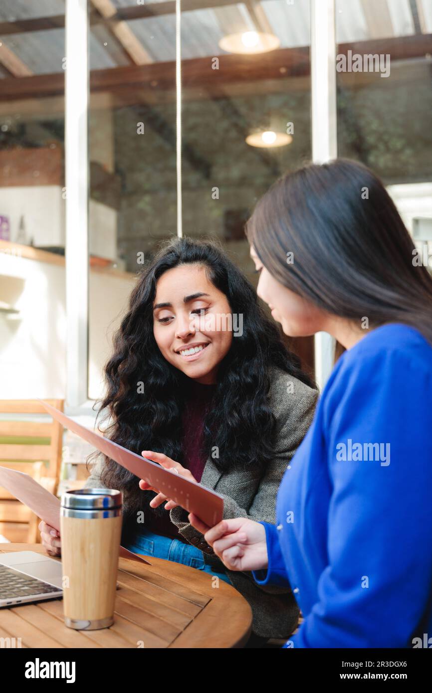 business-lunch-break-two-young-latina-executives-in-blazers-reading