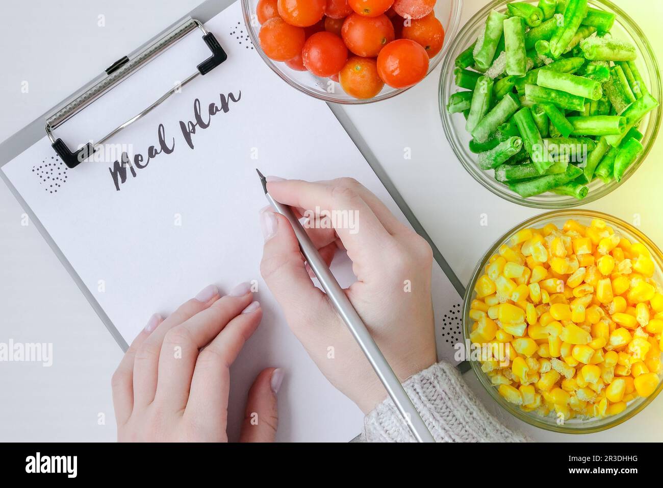 Meal plan. Three Bowls of frozen vegetables food of yellow corn, green beans, red tomatoes. Colors of traffic light. Harvest Foo Stock Photo