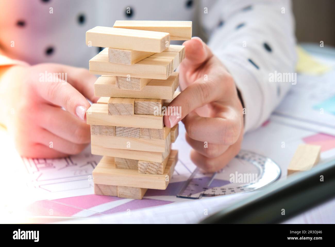 Architect designer Interior creative working hand playing a block wood game on desk architectural plan of the house, a color pal Stock Photo