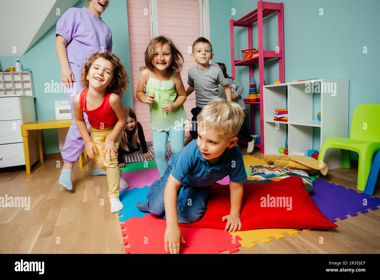 Happy kids actively playing at the daycare Stock Photo