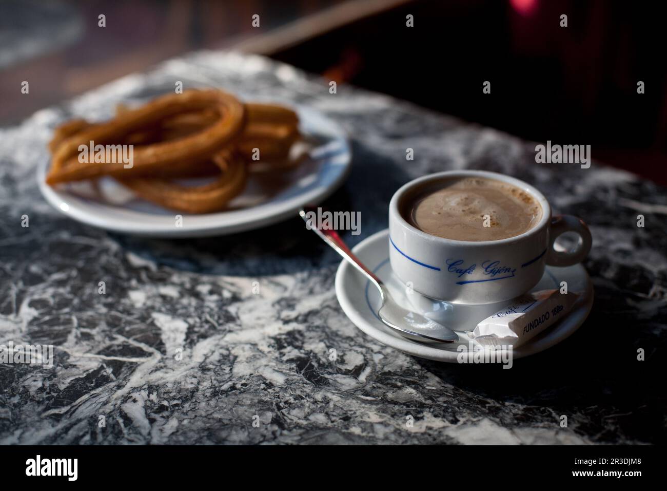 A café con leche (coffee with milk) and churros (at the famous Café Gijón. Madrid, Spain. Stock Photo
