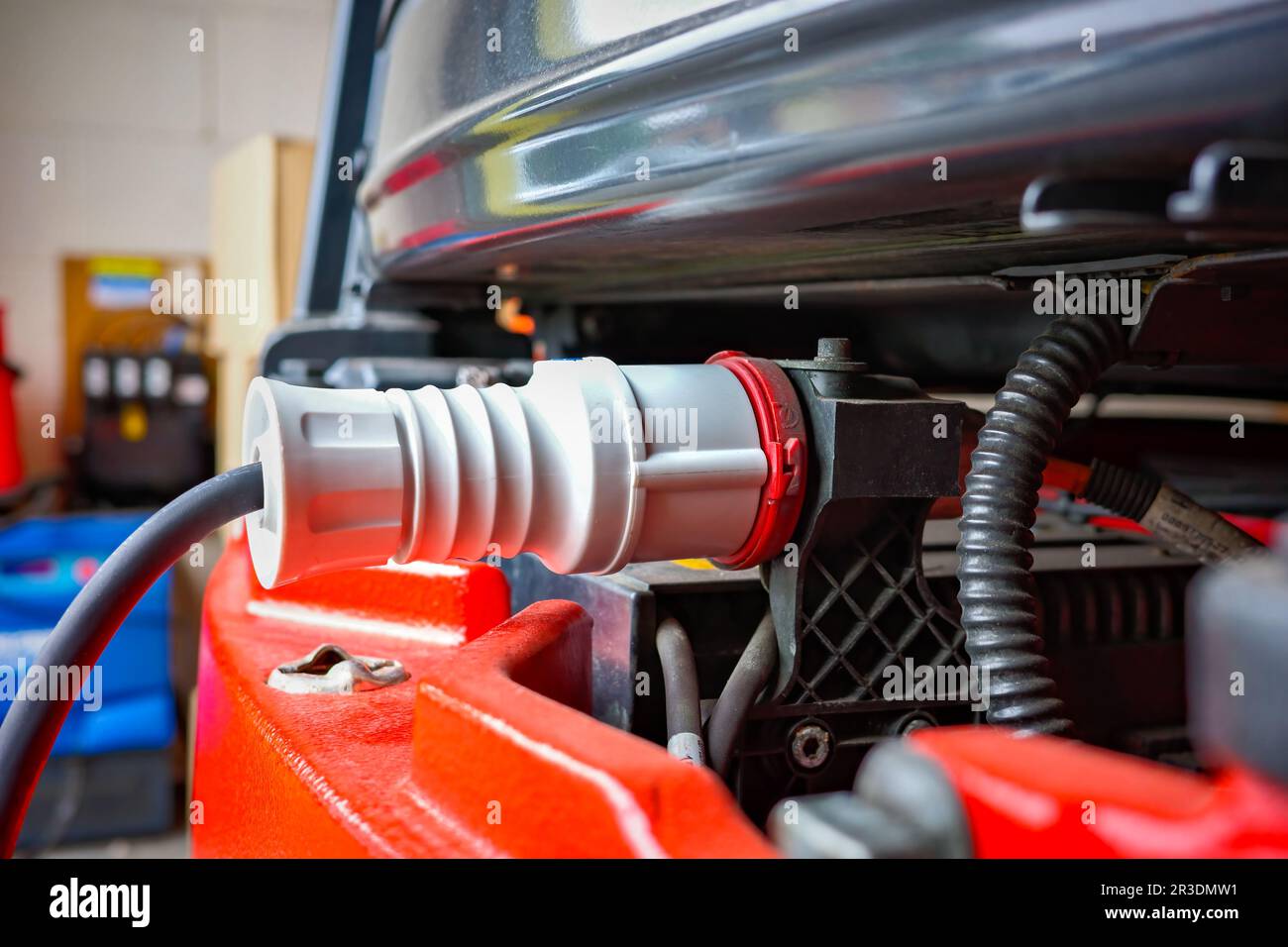 Fork lift truck with electric cable plugged in for recharging the batteries Stock Photo