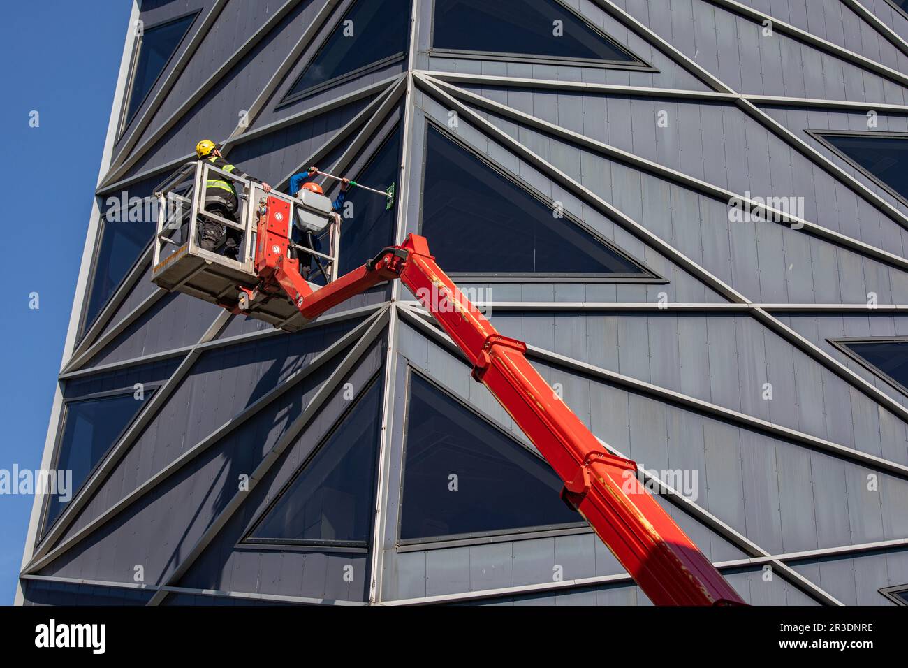 Modern architecture. Window cleaning crew on articulating boom lift in Rotermanni Quarter of Tallinn, Estonia Stock Photo