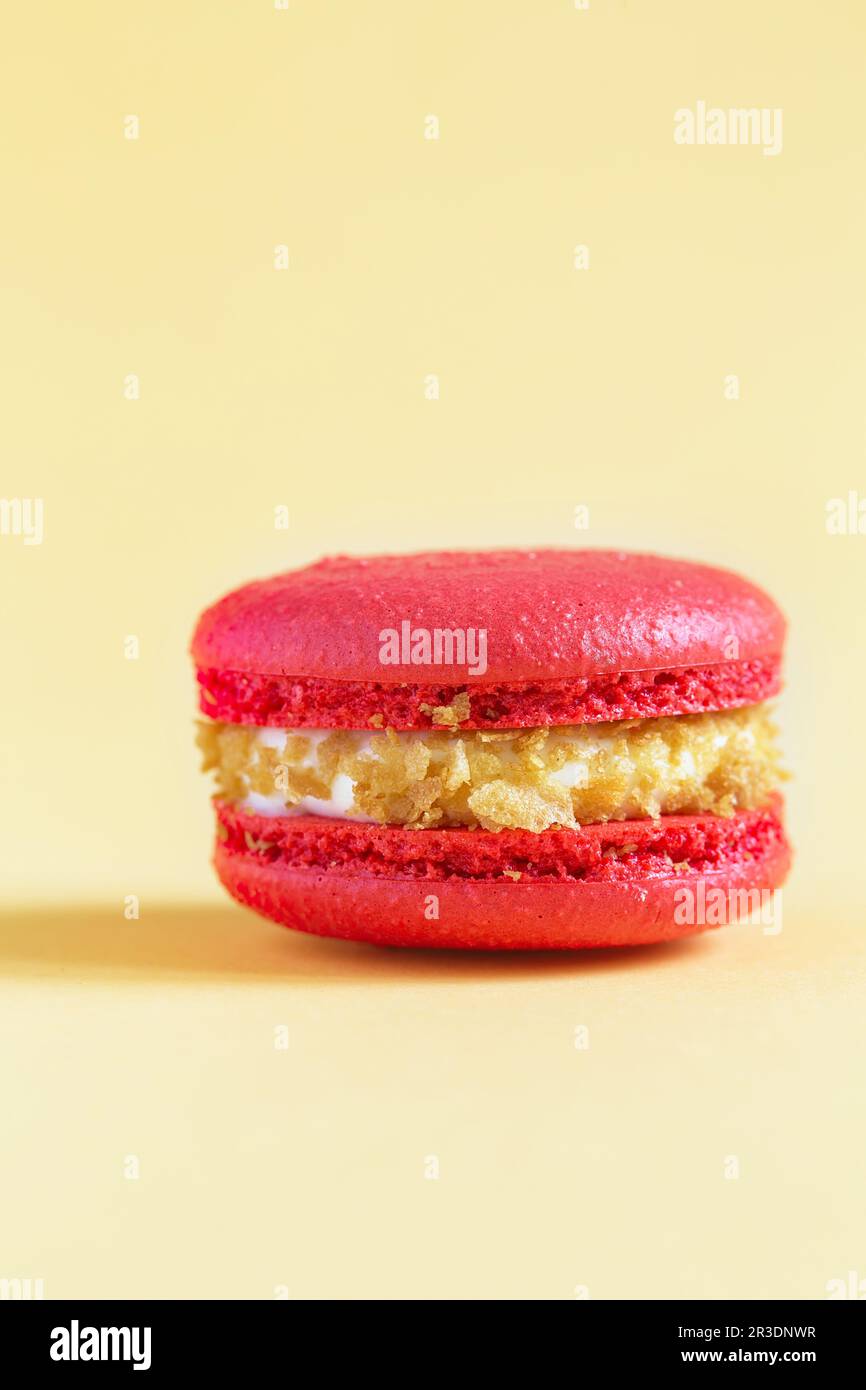 Red Cake macaron or macaroon on yellow background. Stock Photo