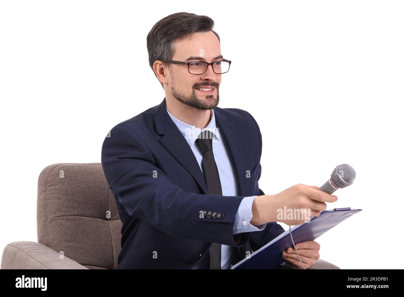 Male journalist with microphone and clipboard in armchair on white