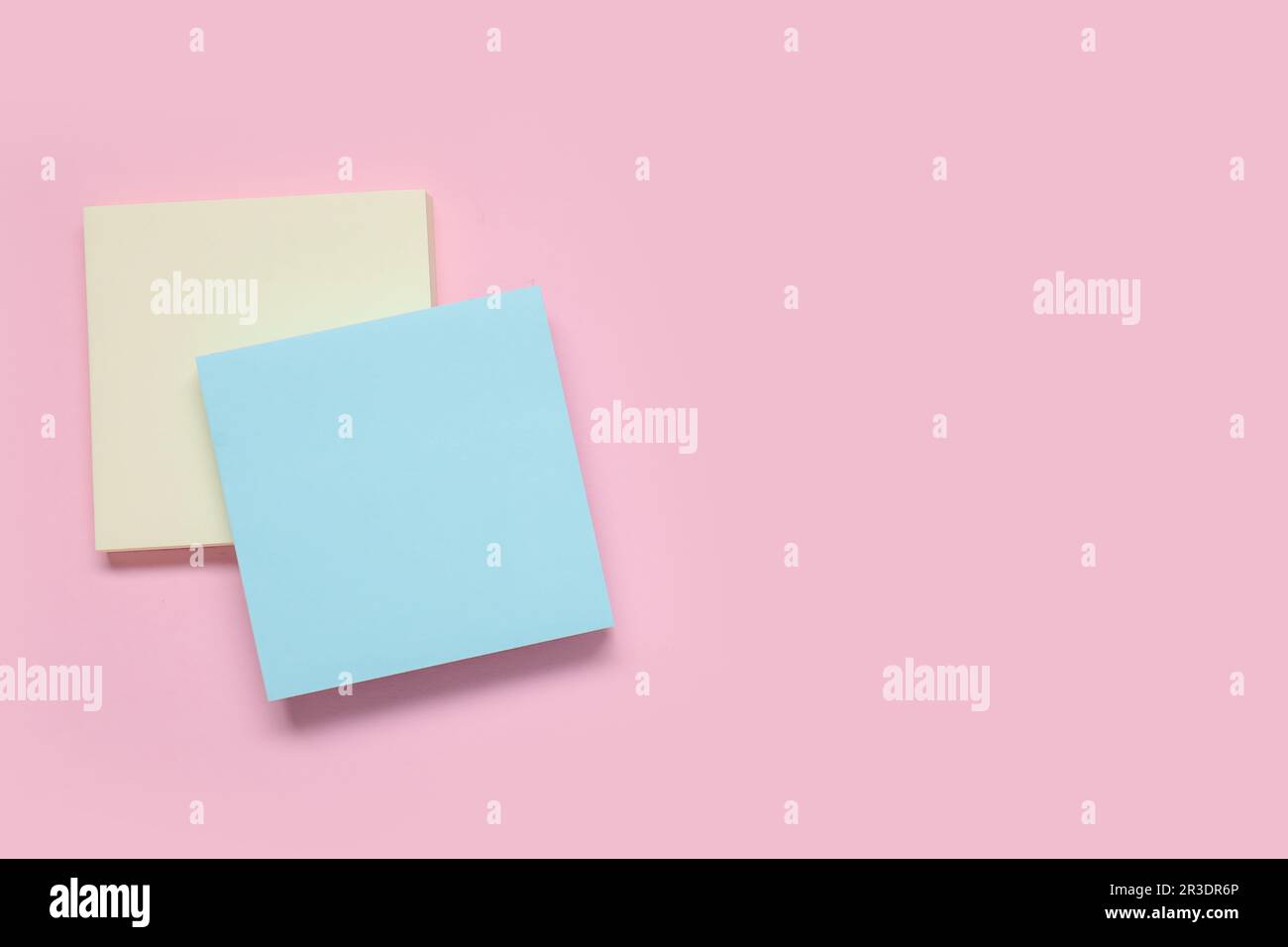 Sticky notes on pale pink background Stock Photo