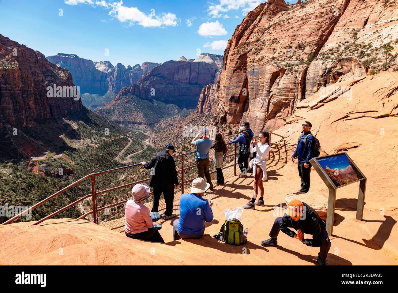 Asian man stretching. Tourists & hikers at top of Canyon Overlook Trail; Zion National Park; Utah; USA Stock Photo