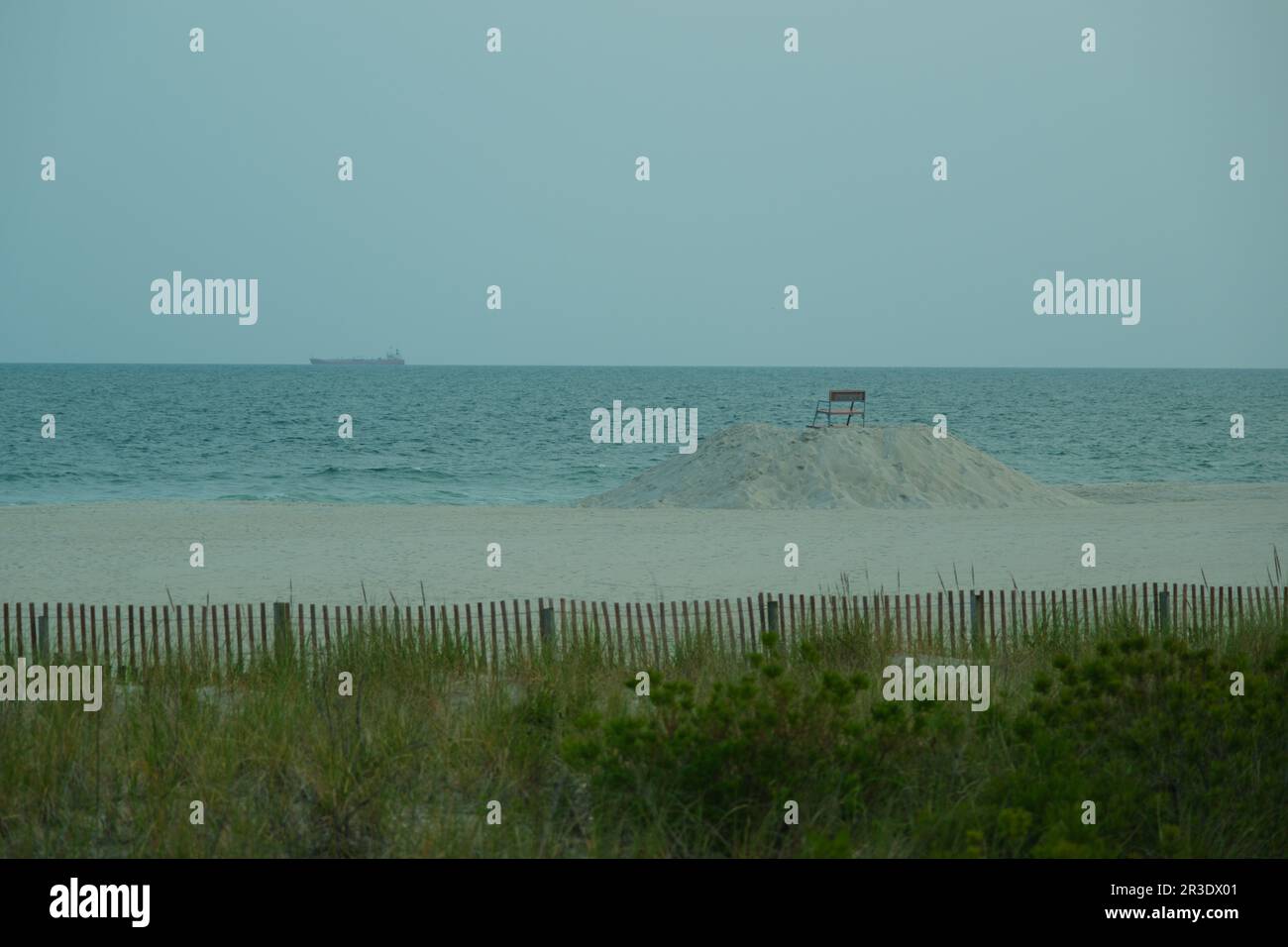 View of the ocean with a bench on a mound of sand, Long Beach, New York Stock Photo