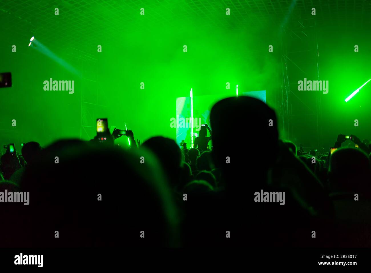 A crowd of people at the concert have fun and dance to the music at the ...