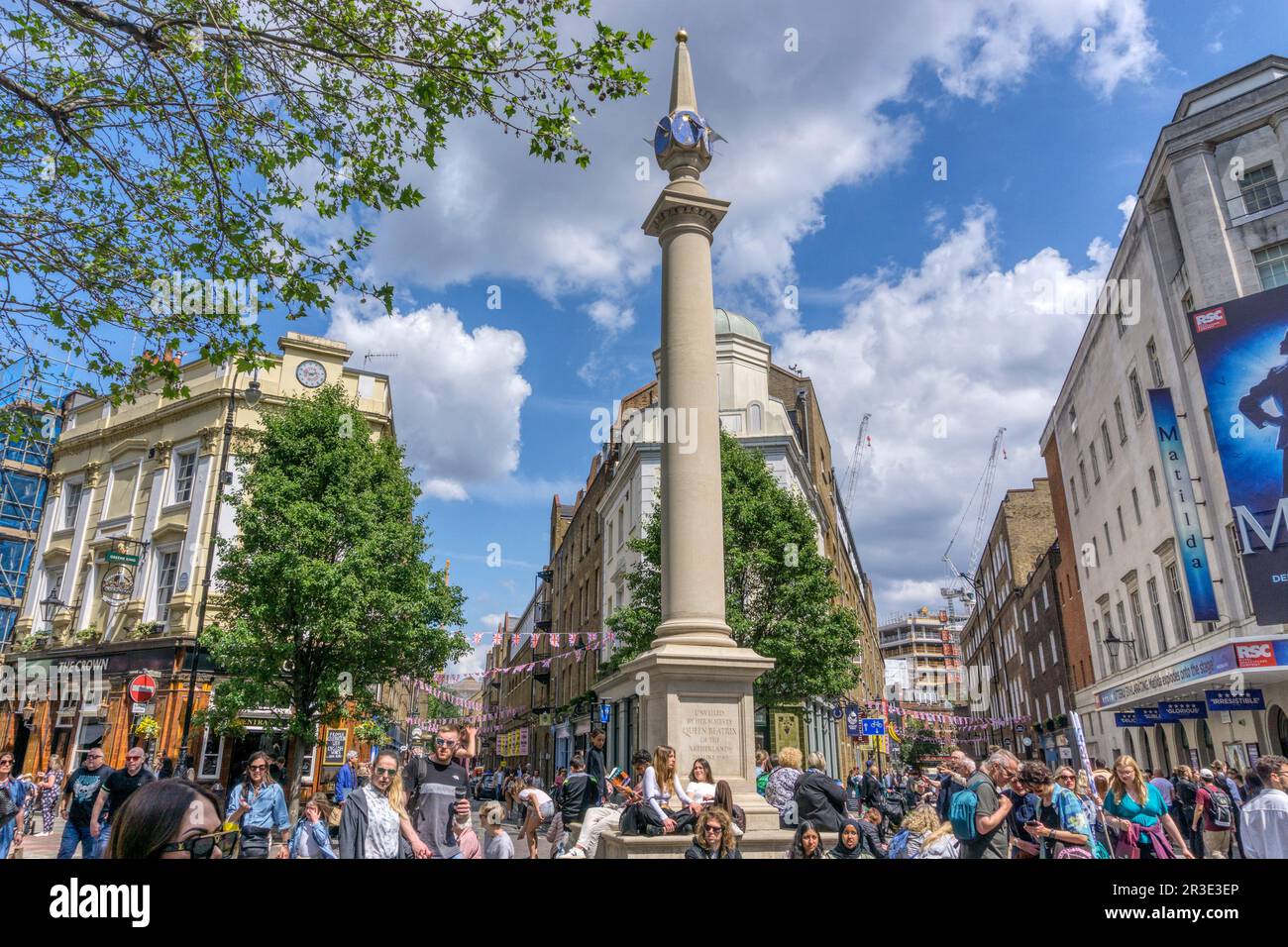 People enjoying the sunshine around Seven Dials near Covent Garden in Central London. Stock Photo