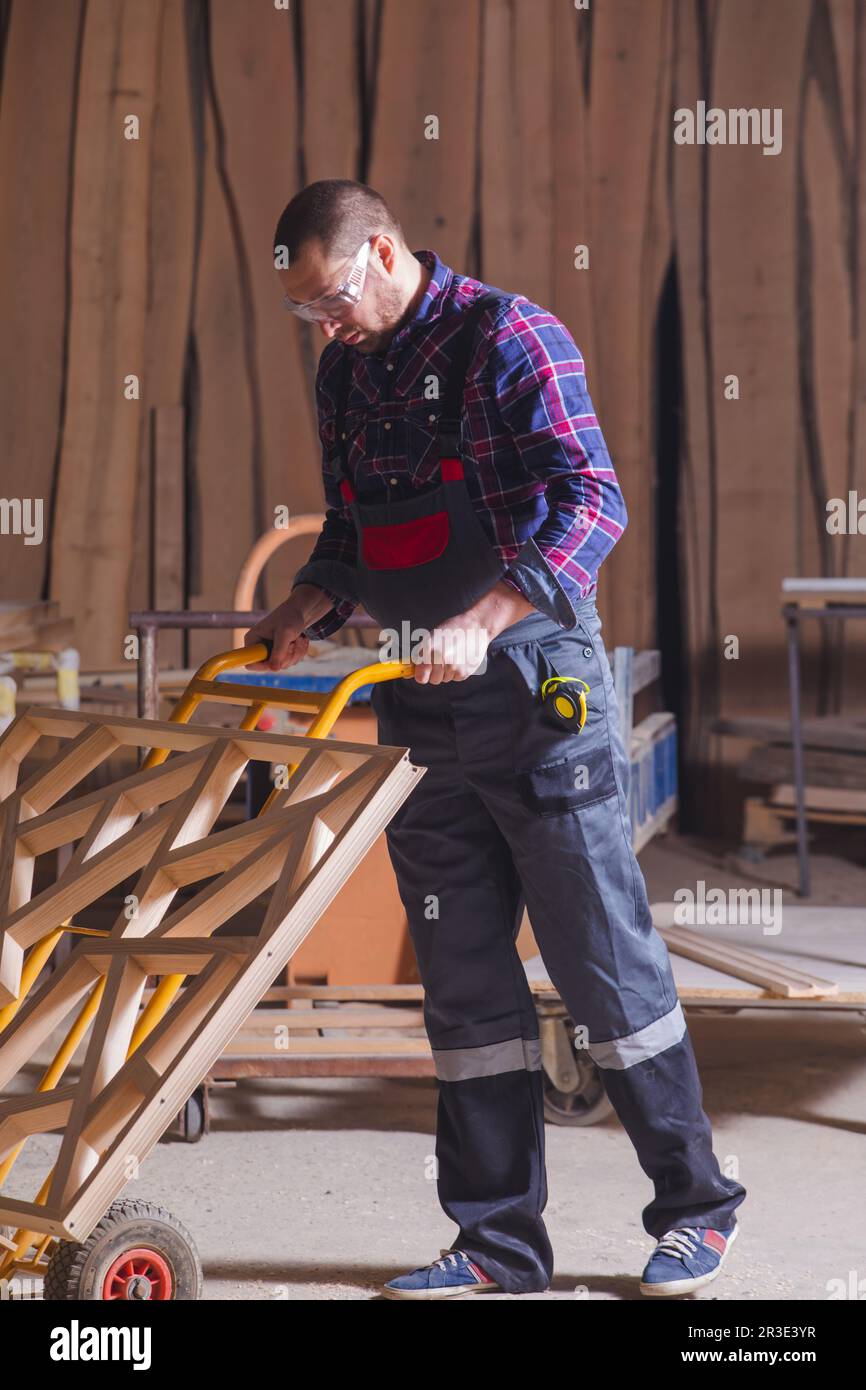 Man transporting wooden decorative element using hand truck Stock Photo