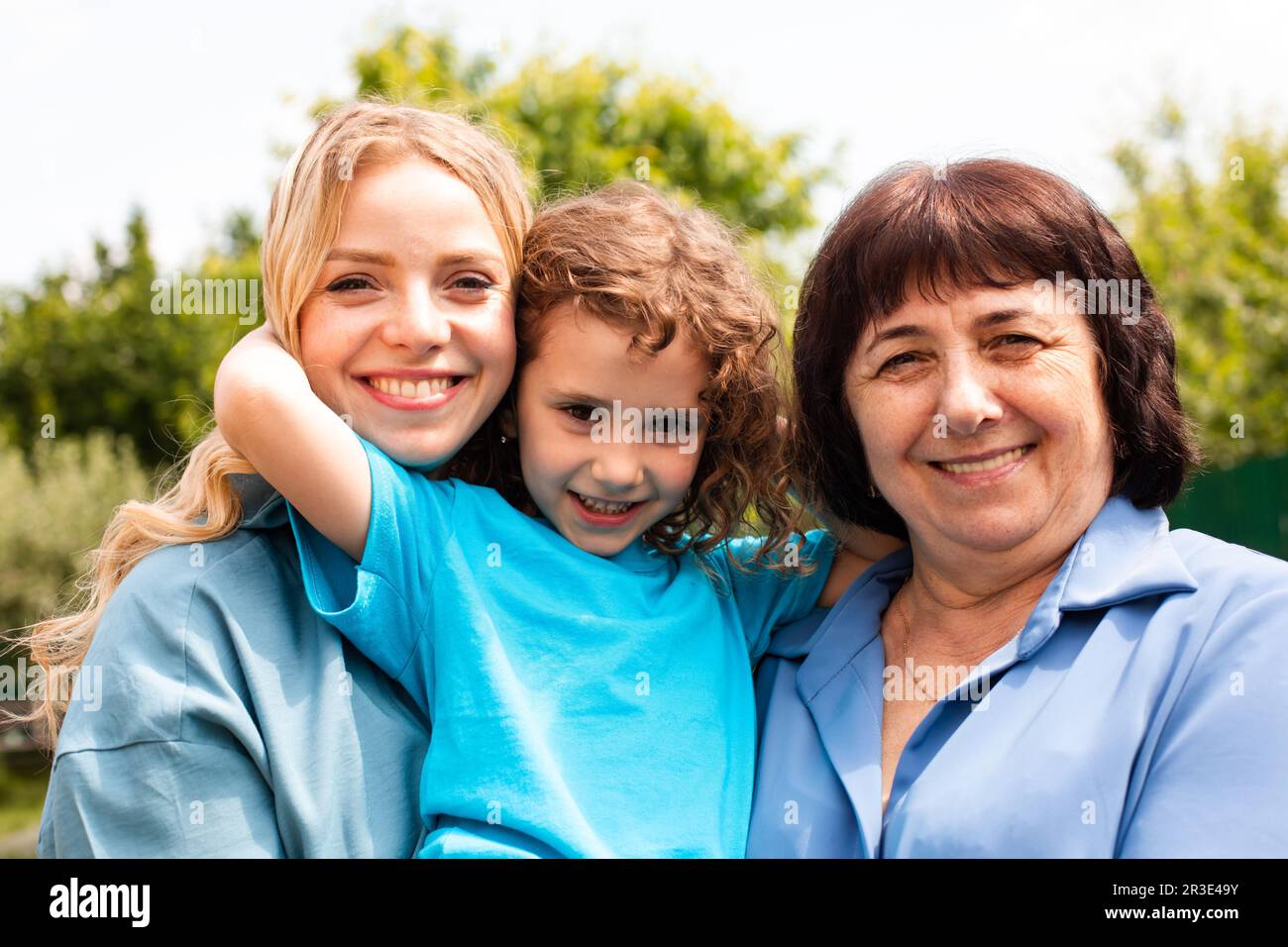 Cute girl embracing mother and grandmother outdoors Stock Photo