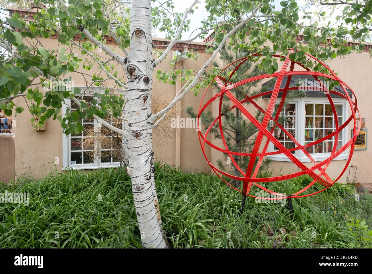 Birch tree and red metal art piece at a gallery in Santa Fe, New Mexico Stock Photo