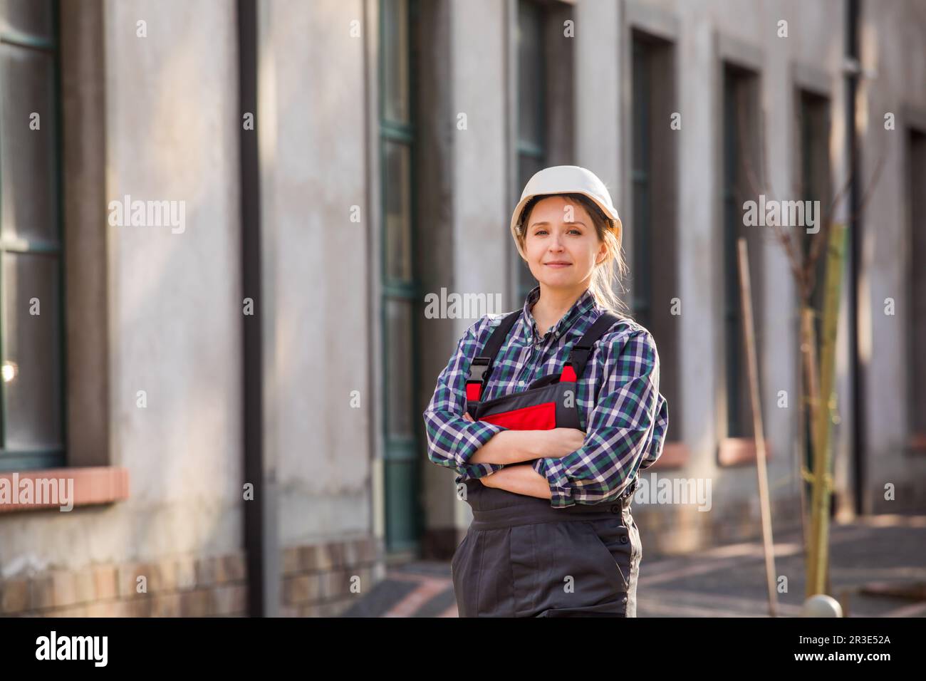 Young girl, manual worker posing outdoors with hands folded on chest Stock Photo