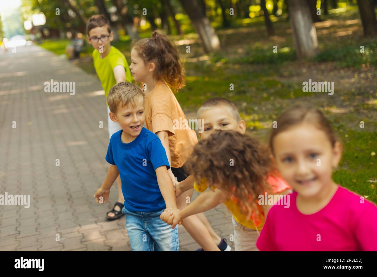 Cute boy playing with friends outdoors in the park Stock Photo