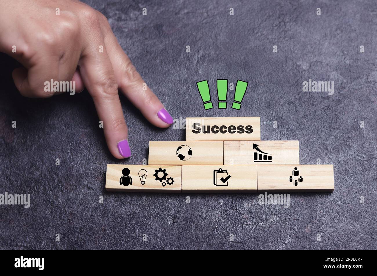Hand fingers climb steps of pyramid of wooden blocks with marks and ...