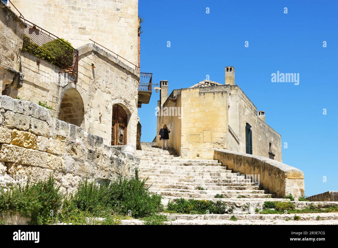 Moments in local daily life in the historic Sassi of Matera, Basilicata region of Italy. Solitary figure, descending on the stairs of old street. Stock Photo