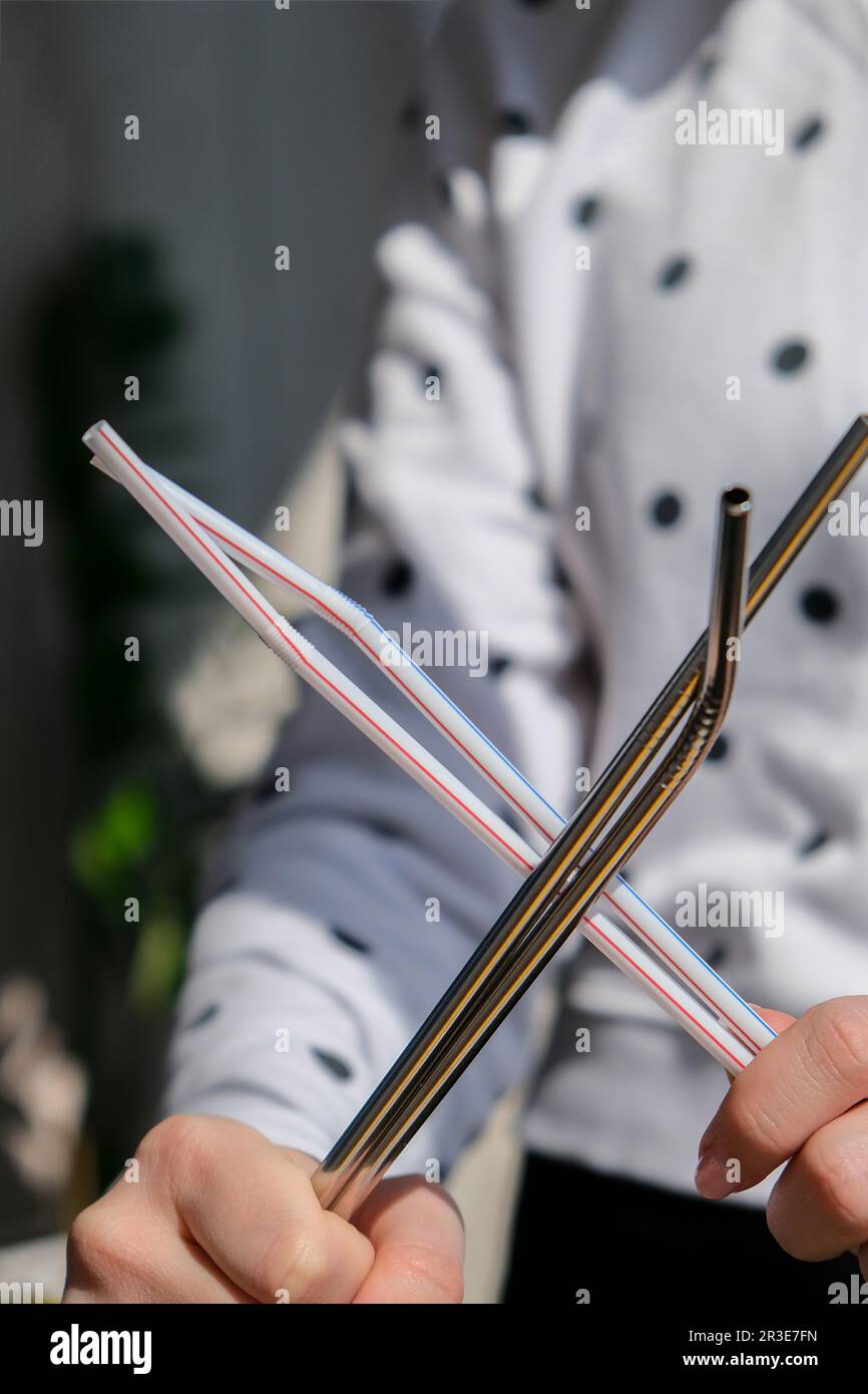 Woman holding Reusable Metal and plastic drinking Straws. Female Hand on reusable collapsible drinking straw. Eco lifestyle and Stock Photo