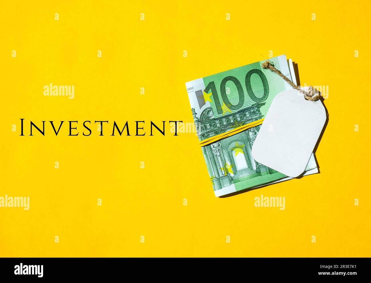Euros money cash in rubber band, note text written INVESTMENT, concept