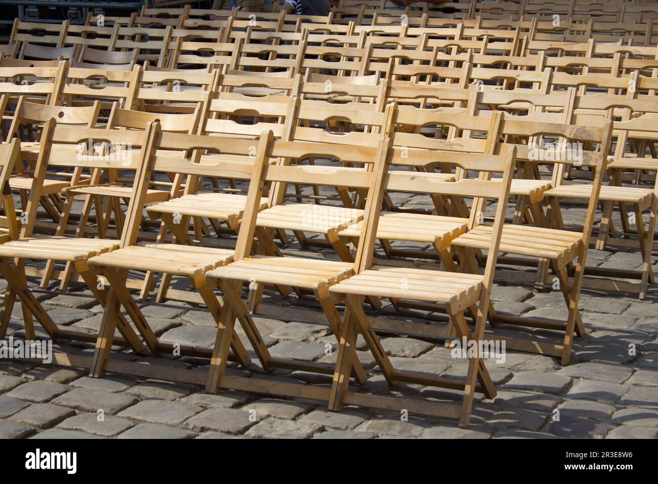 an outstanding event under the open sky, wooden chairs on the streets of the city in a row Stock Photo