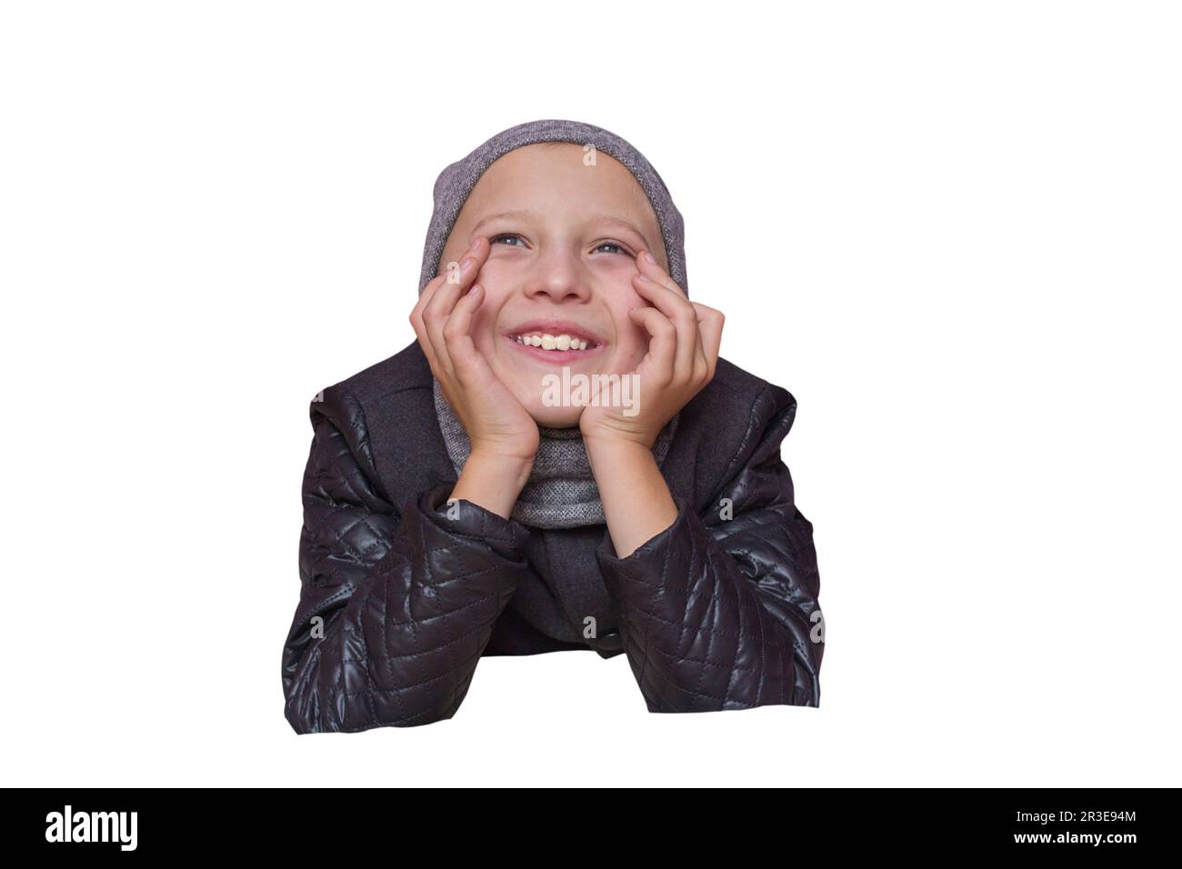laughing boy in autumn clothes supports his face with his hands Stock Photo