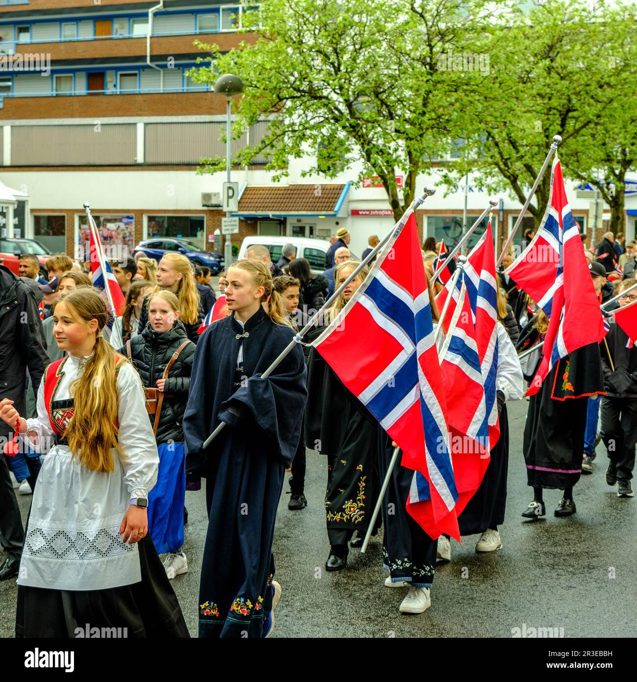 Sandnes, Norway, May 17 2023, Group Of Young Girls or Schoolgirls in Traditional Dress Carrying Flags In Norwegian Independence Day Parade Stock Photo