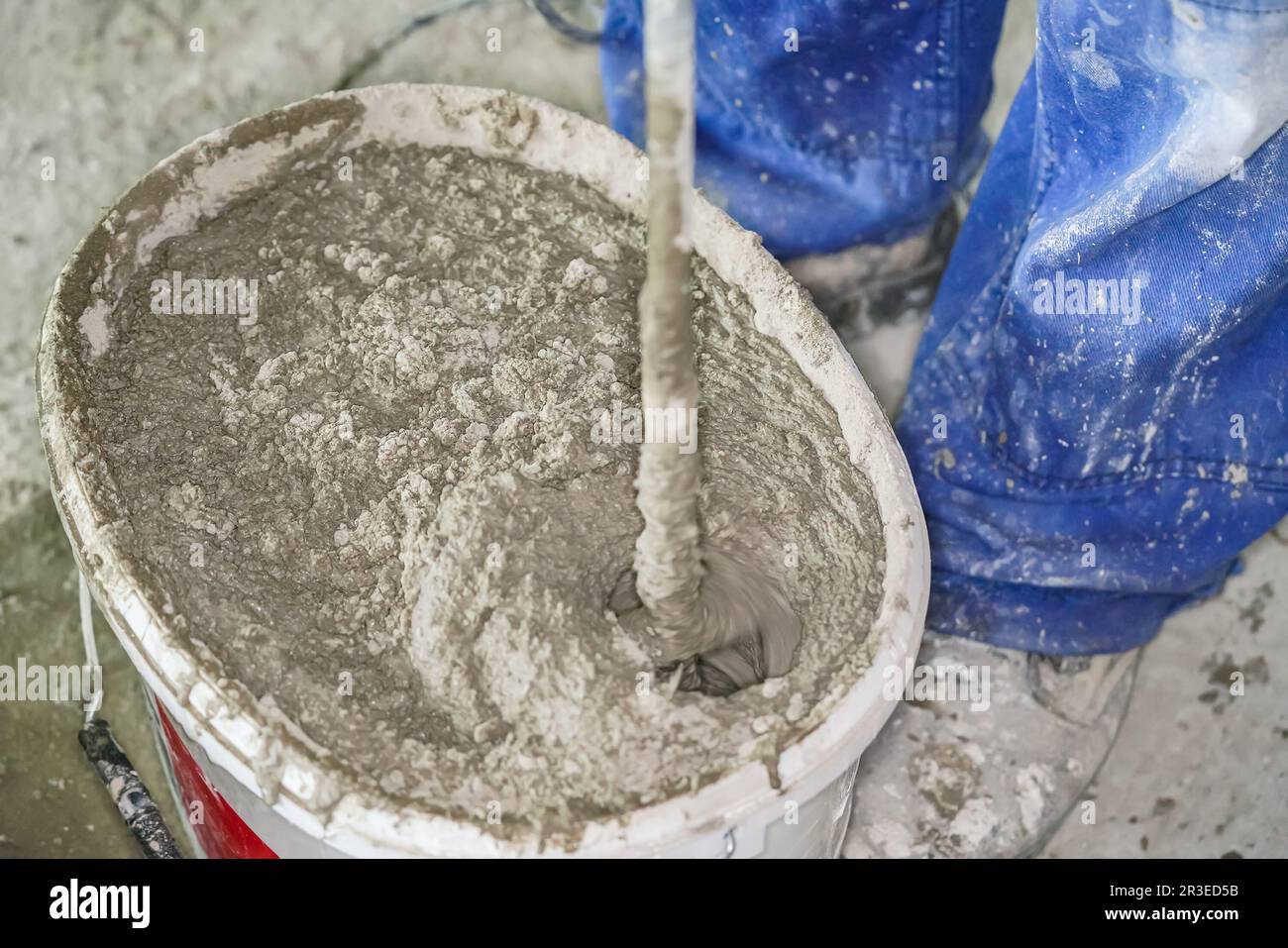 Mortar cement paste, mostly dry, mixed in bucket at house construction