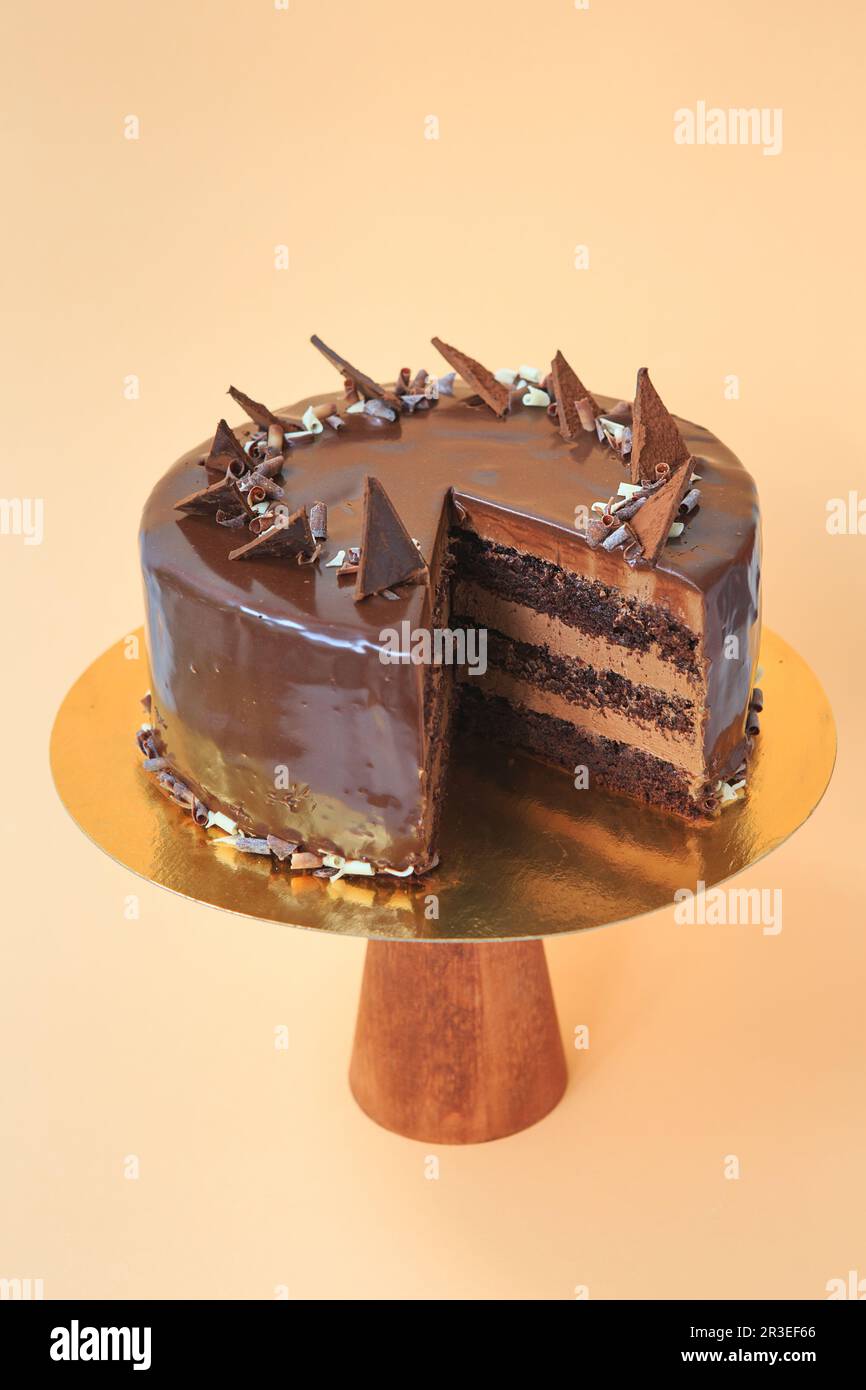 Sliced Birthday cake on the wooden cake stand. Beautiful sponge cake on the paper background. Copy s Stock Photo