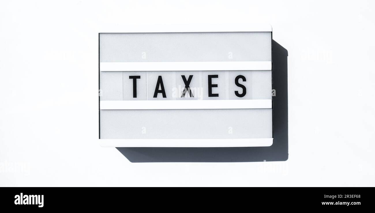 Lightbox board on a white background with the words TAXES in black letters. Stock Photo