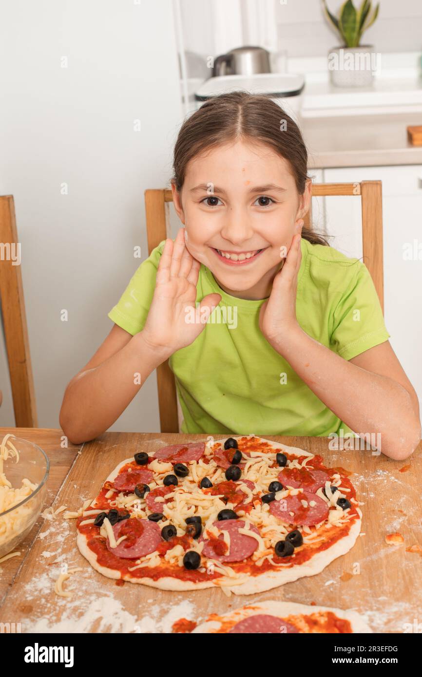 The little girl cooked her favorite pizza Stock Photo