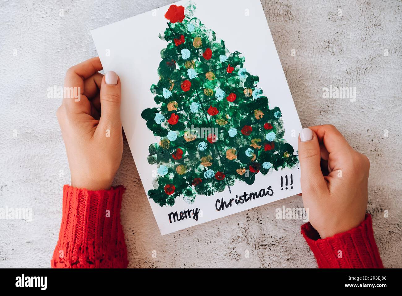 DIY Making greeting card Handmade crafts on holiday for children. Paint with fingers Merry Christmas tree. Step by step. Happy N Stock Photo