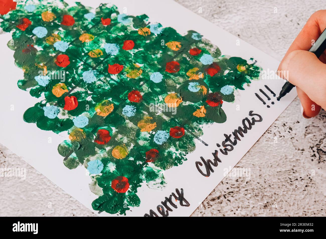 DIY Making greeting card Handmade crafts on holiday for children. Paint with fingers Merry Christmas tree. Step by step. Happy N Stock Photo