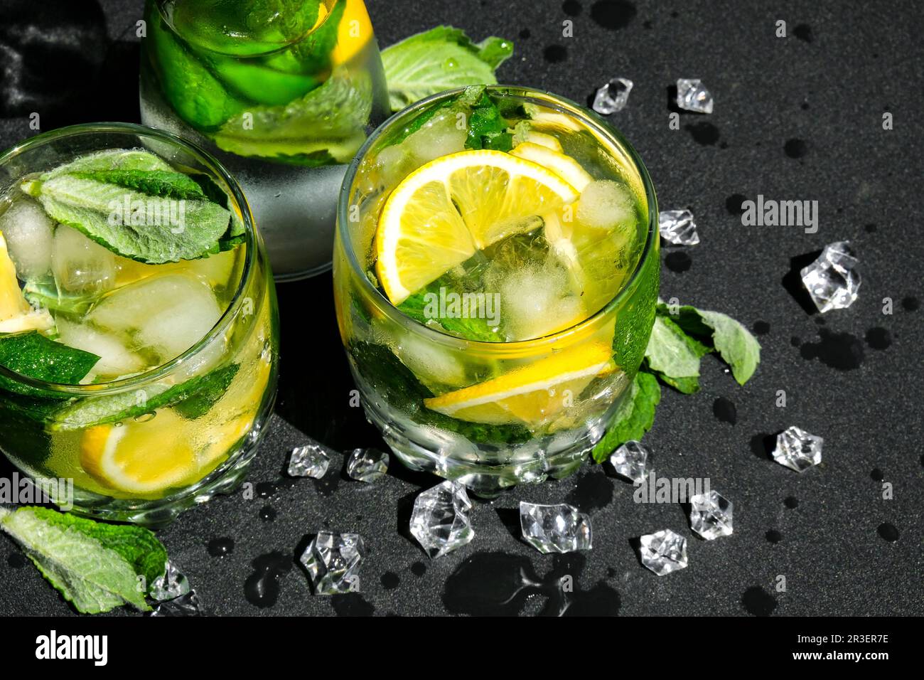Mojito refreshing cocktail, alcohol drink. Lemonade with lemon and mint leaves on dark background. Ice cubes. Summer refreshing Stock Photo