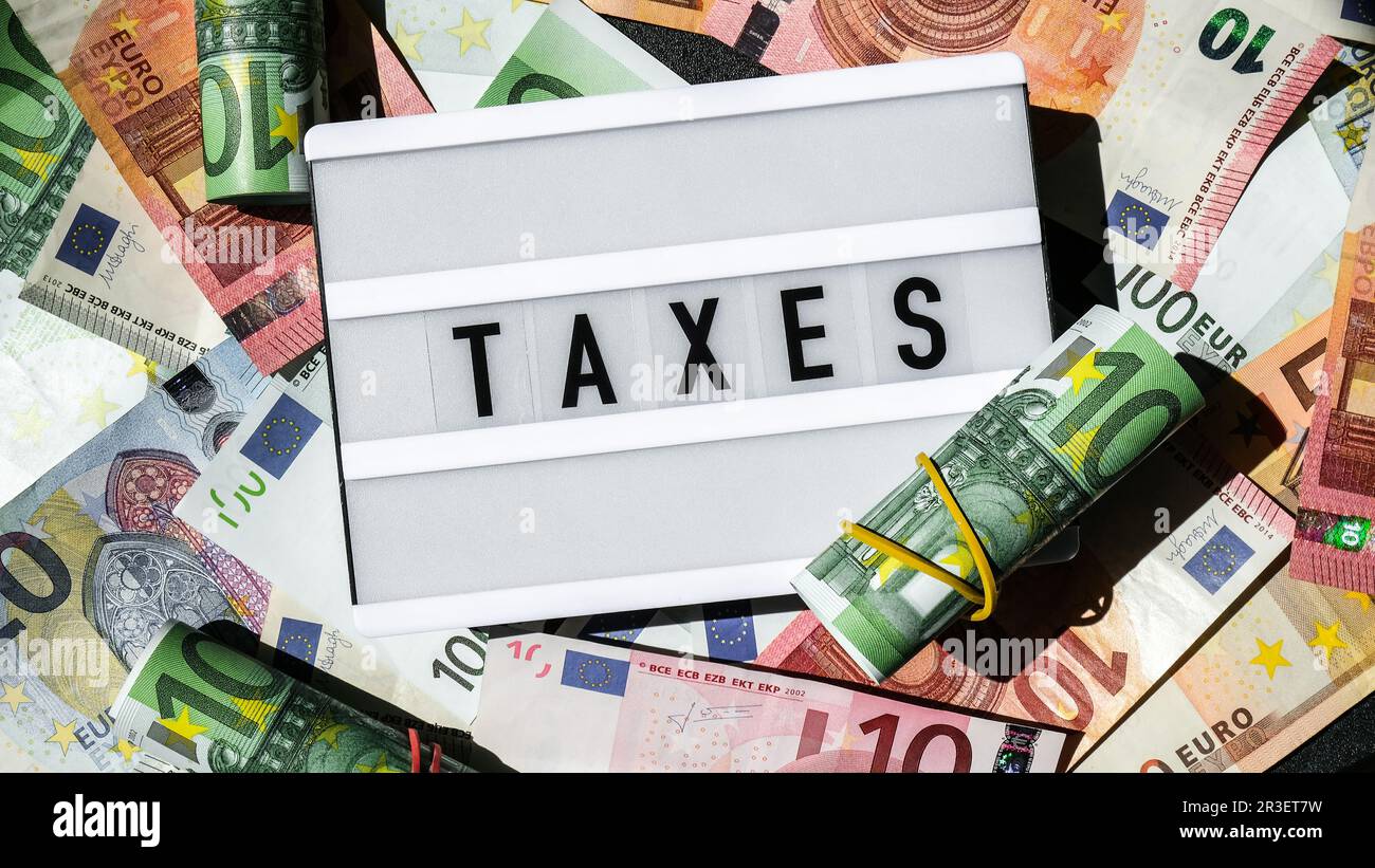 Lightbox board with word TAXES in black letters around Euro banknotes. Tax payment and filing concept. Money, Business, finance, Stock Photo