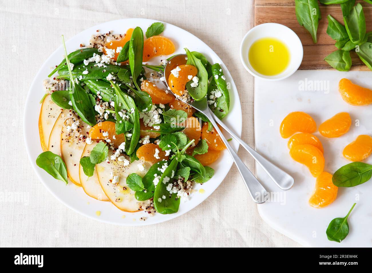 Spinach and quinoa salad with pears, oranges and ricotta. Healthy Meal prep. Plant-based dishes. Green living. Vegan recipe. Foo Stock Photo
