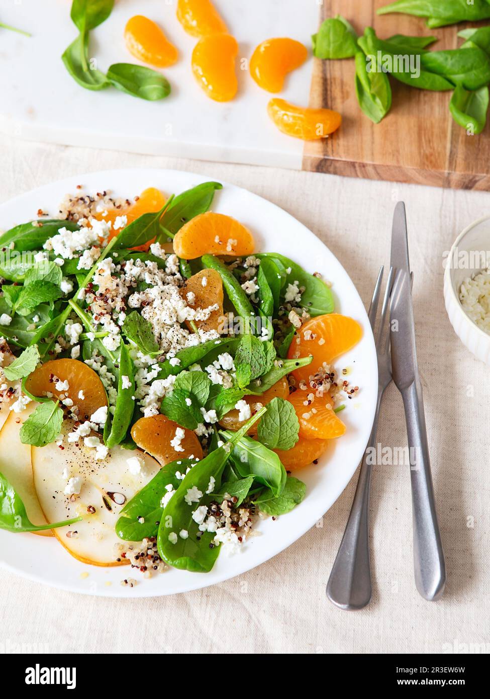 Spinach and quinoa salad with pears, oranges and ricotta. Healthy Meal prep. Plant-based dishes. Green living. Vegan recipe. Foo Stock Photo
