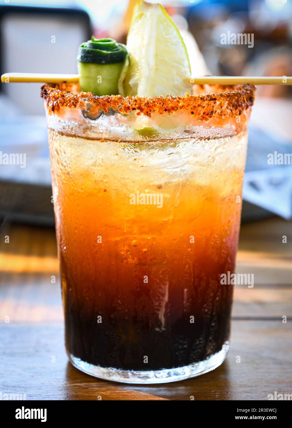 Michelada beer with tomato juice clamato with beer on wooden table