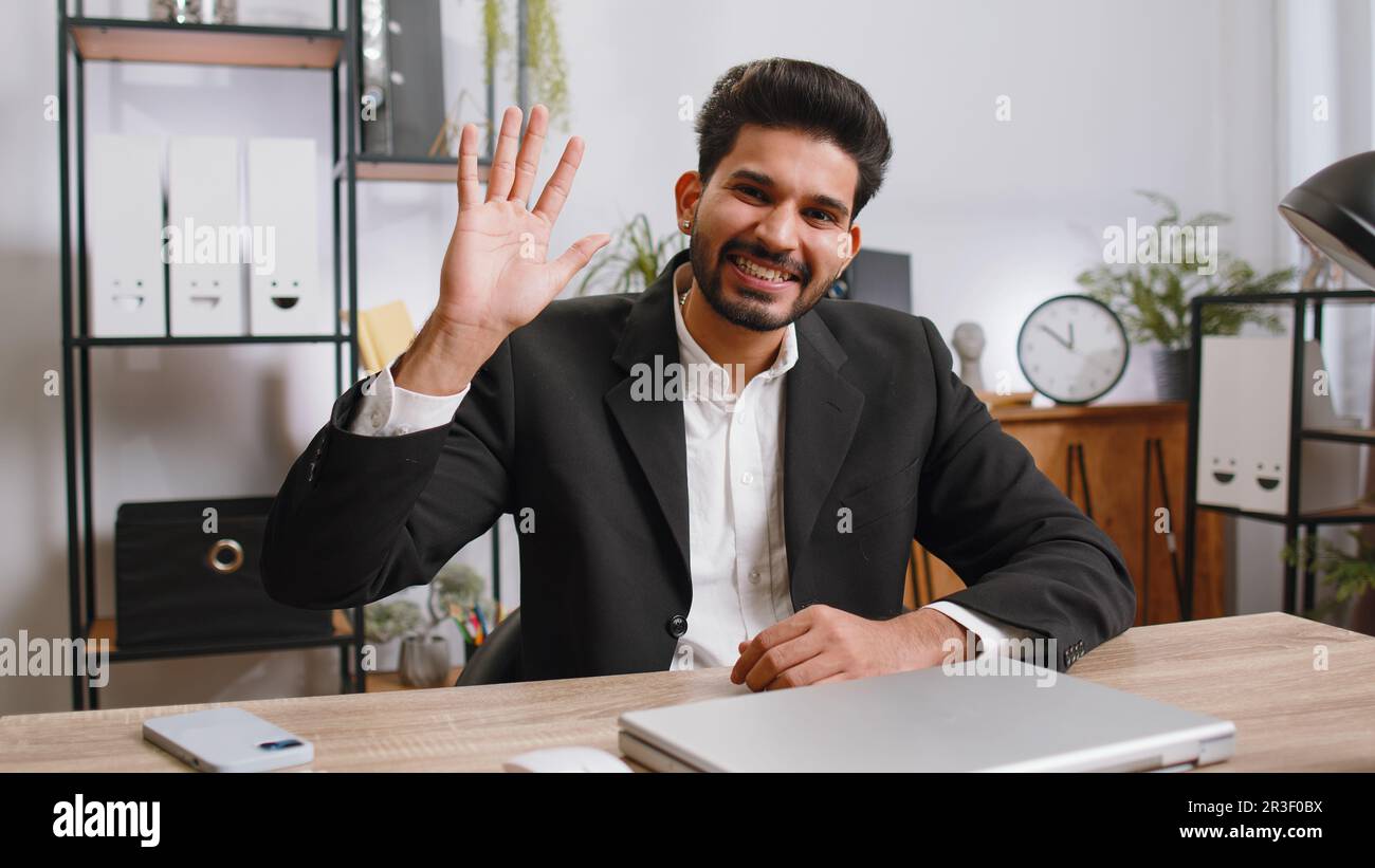 Indian business man working on laptop computer smiling friendly at ...