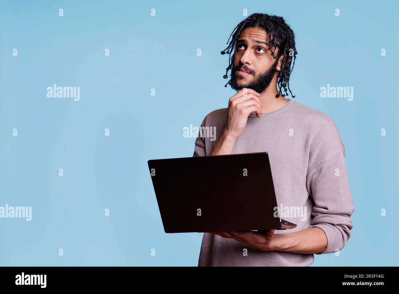 Arab man reading programming report on laptop Stock Photo