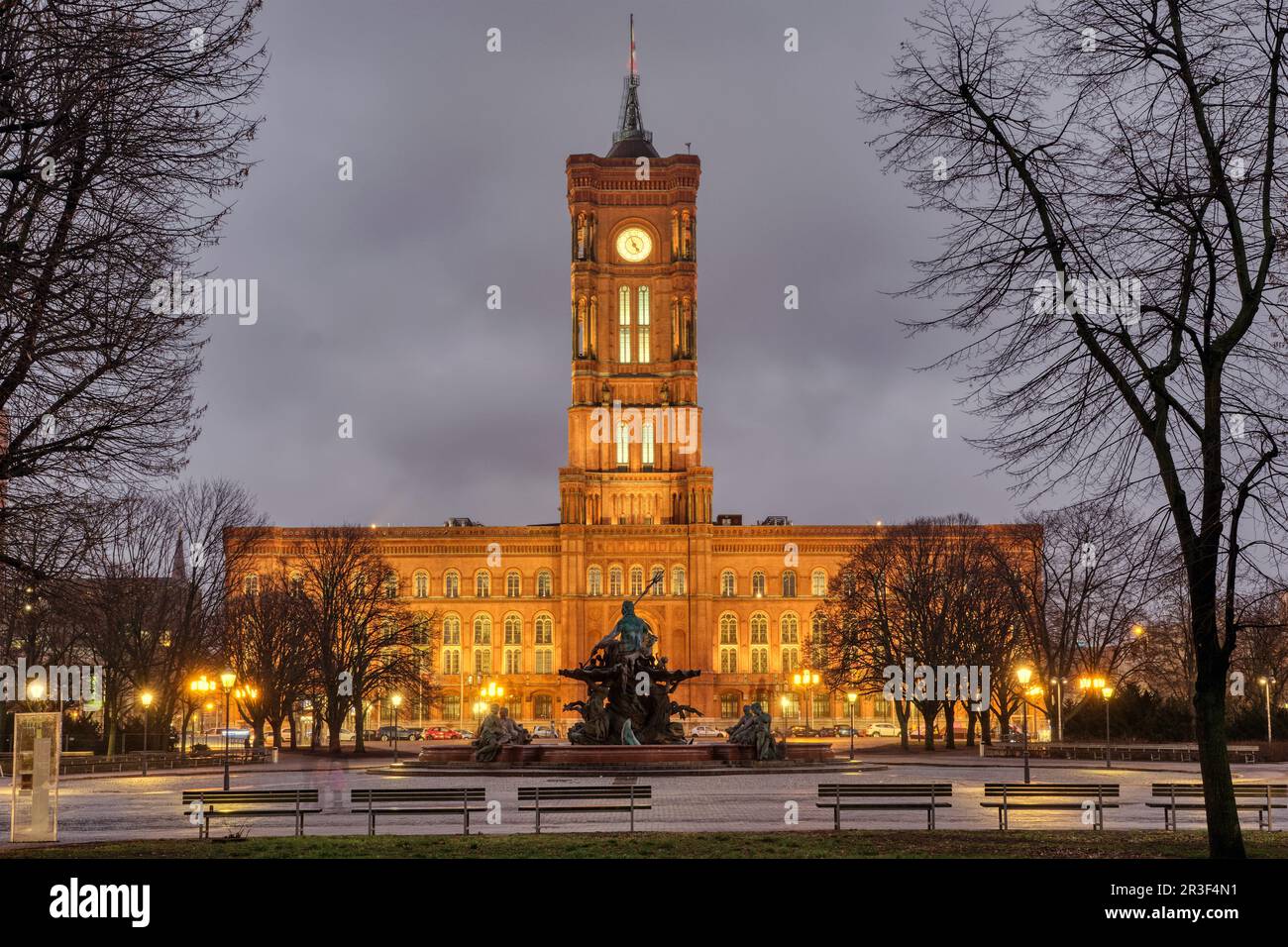 The famous Rotes Rathaus in Berlin at night in winter witrh some barren tree branches Stock Photo