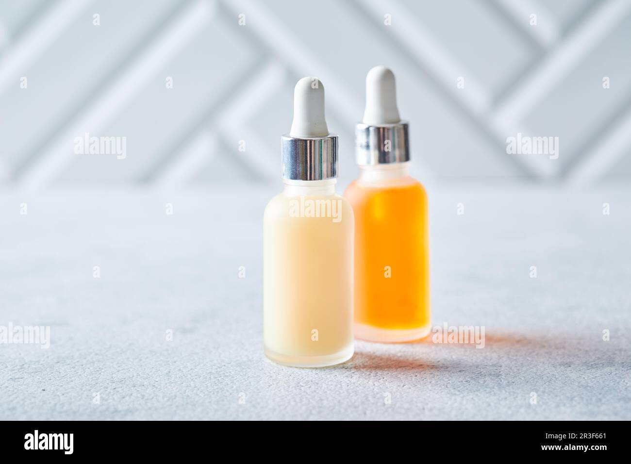 Glass bottles with face or body skin care products on a light background. Self-care, cosmetics, beauty practices, self-care conc Stock Photo