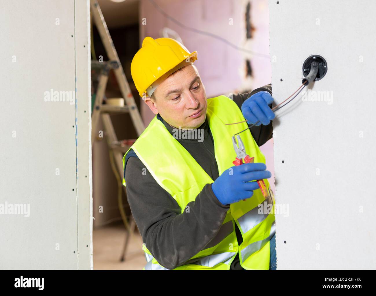 Electrician installing electricity in new house Stock Photo Alamy