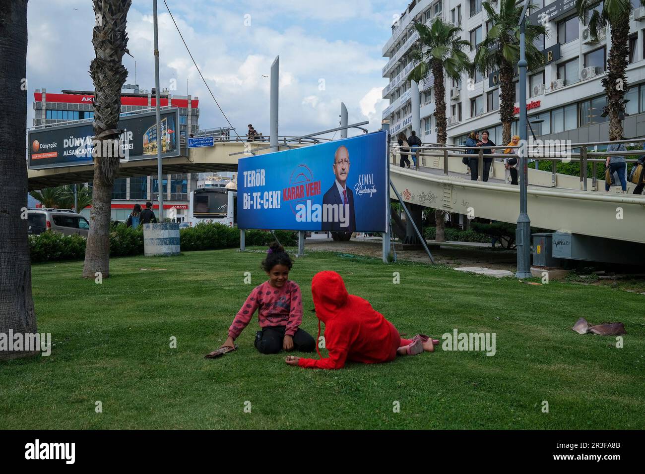 Izmir, Turkey. 23rd May, 2023. Child play next to the election poster of Kemal Kilicdaroglu along the street in Izmir. With the 2023 presidential election, the biggest election in Turkey, to the second round, the candidates started to make their propaganda with re-election posters. In the first round, Recep Tayyip Erdogan received 49.5% of the vote, while Kemal Kilicdaroglu received 44.89% of the vote. The second and final round of the elections will be held on Sunday, May 28. (Photo by Murat Kocabas/SOPA Images/Sipa USA) Credit: Sipa USA/Alamy Live News Stock Photo