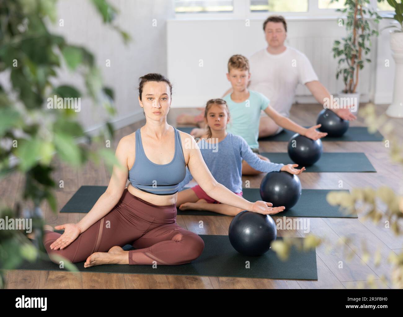 Family with two kids doing pilates with softball Stock Photo - Alamy