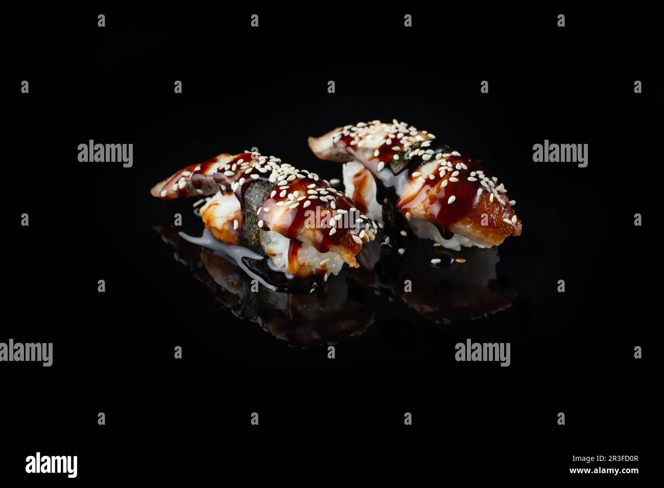 Traditional fresh Delicious Unagi Eel Nigiri Sushi (Eel Sushi)  on a black background with reflection. Traditional Japanese cuis Stock Photo