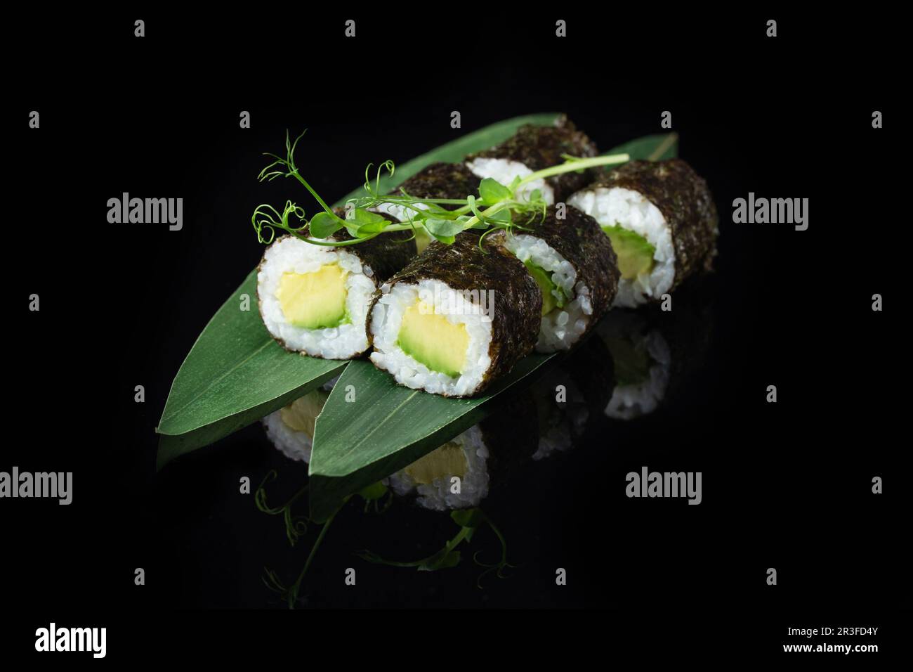 Traditional delicious fresh sushi roll set on a black background with reflection. Sushi roll with rice, nori, cream cheese, tobi Stock Photo