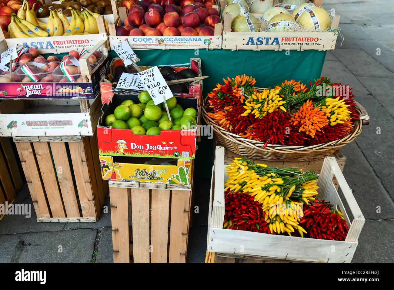 Close-up of a fruit and vegetable stand with chili peppers, melons and peaches at the Rialto Market in summer, Venice, Veneto, Italy Stock Photo